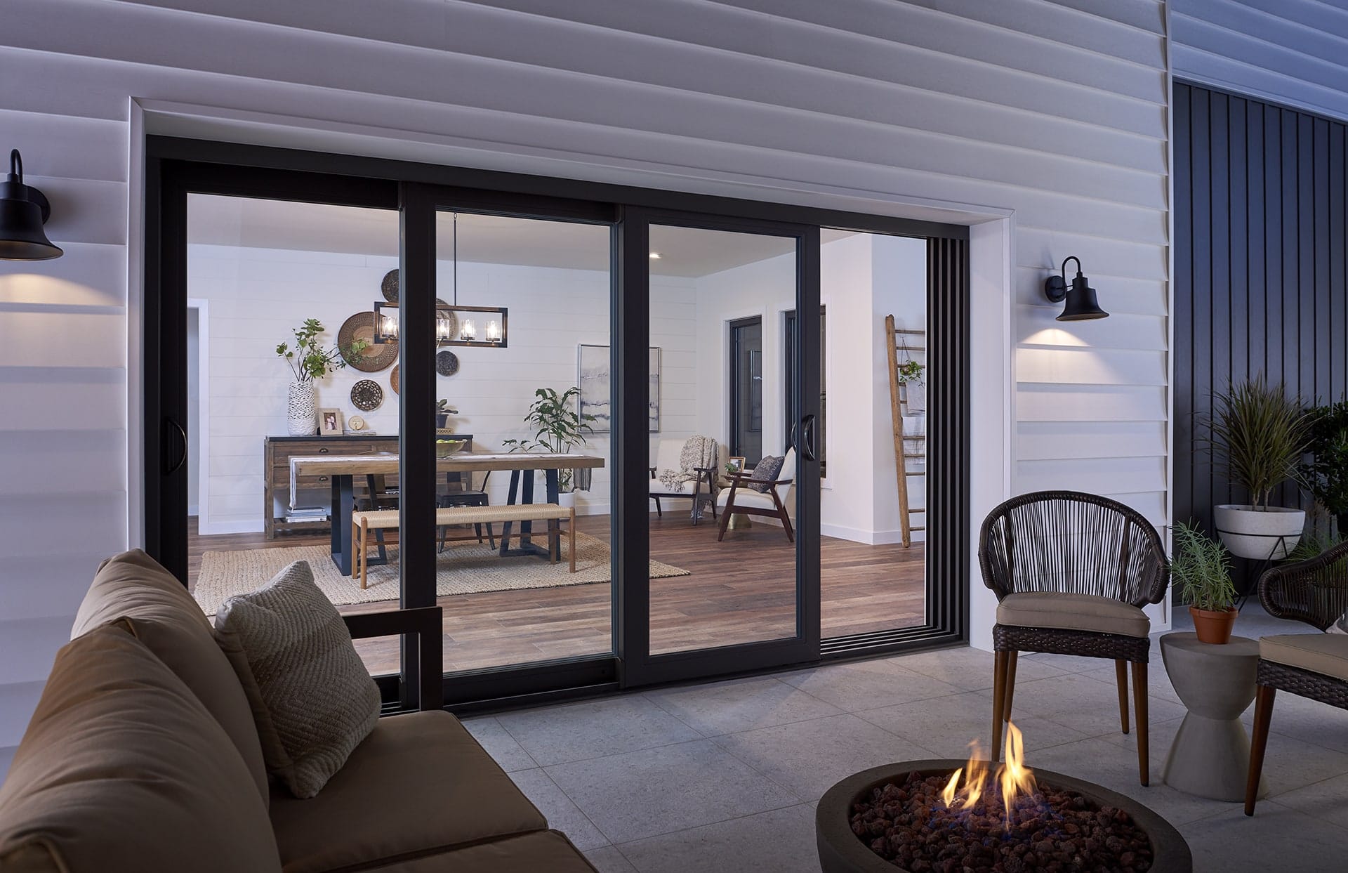 Black French rail door opens to modern patio with fire pit