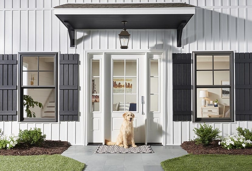 white house with wood windows and a dog