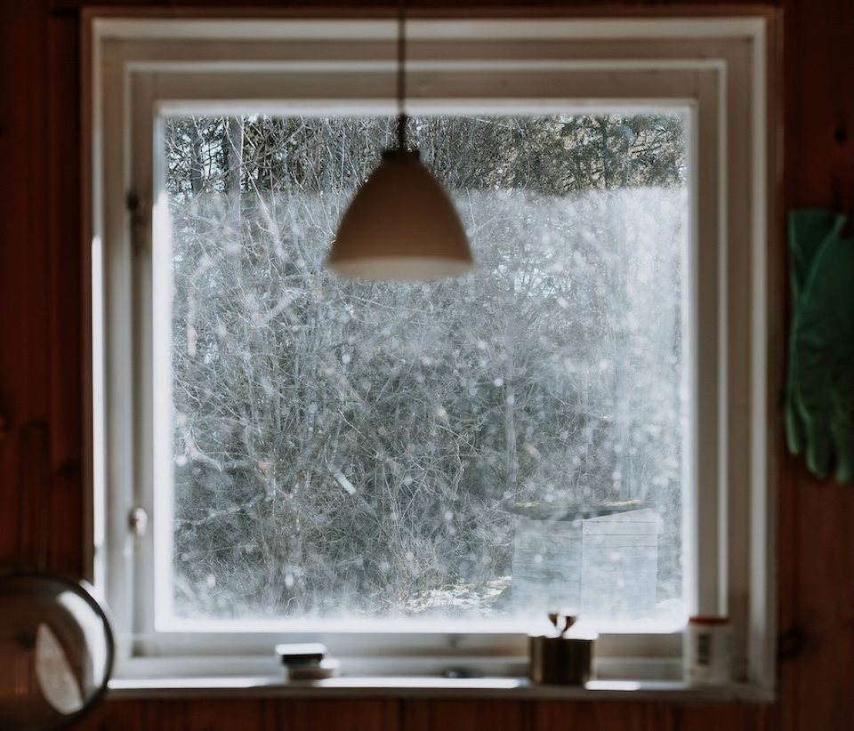 large living room window overlooking winter woods
